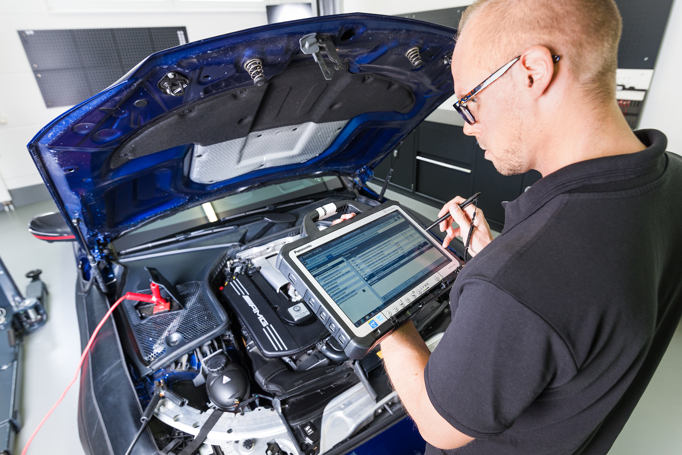 Markus Mangold mit Diagnose-Tablet in der Werkstatt