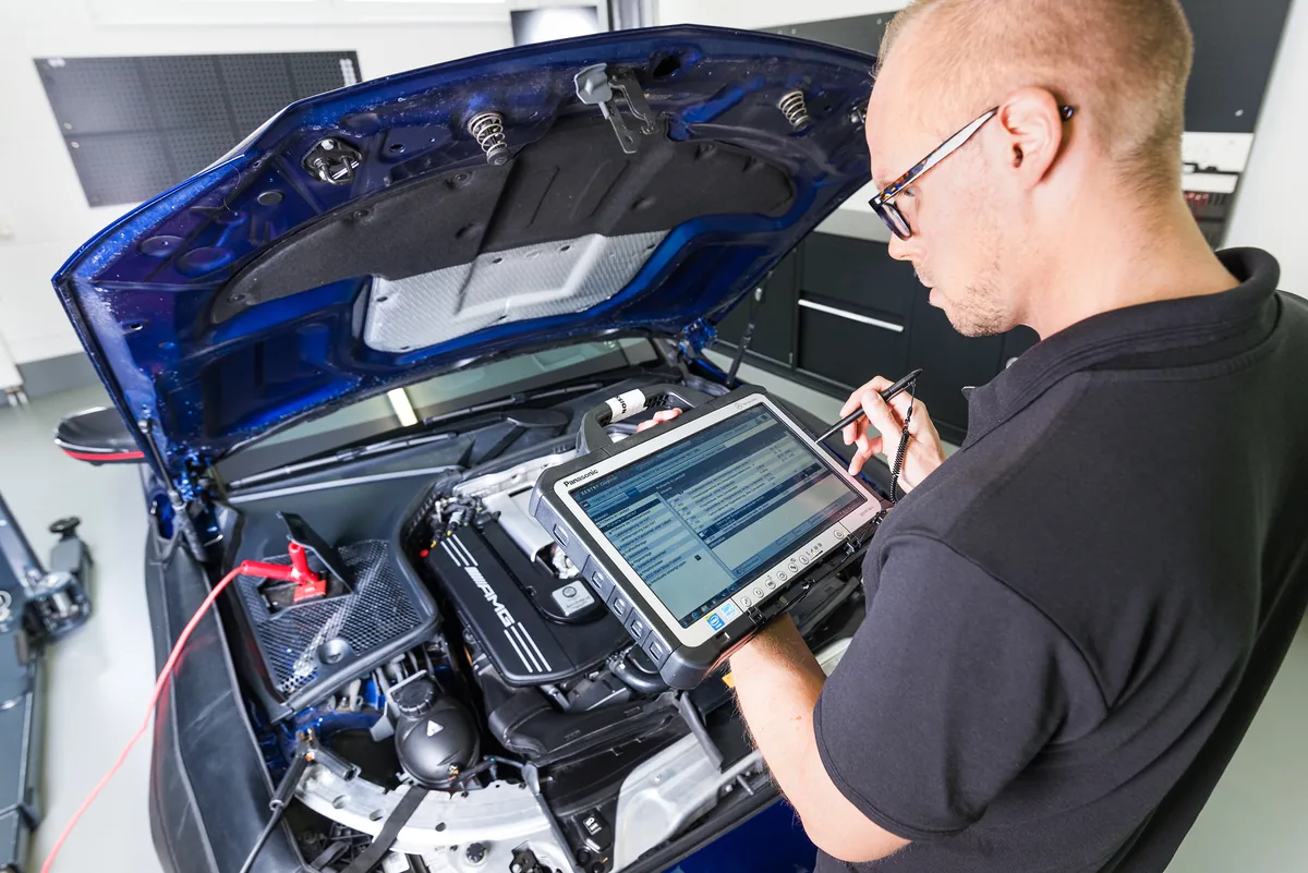 Markus Mangold mit Diagnose-Tablet in der Werkstatt
